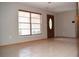 Bright living room with a tiled floor, front door, and large window at 12488 Harper St, Spring Hill, FL 34609
