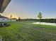 Beautiful view of the backyard, waterfront pond, green space, and surrounding homes at 13014 Willow Grove Dr, Riverview, FL 33579
