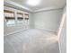 A bright bedroom featuring new carpet, tray ceiling, and large windows at 13014 Willow Grove Dr, Riverview, FL 33579