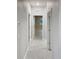 Hallway with neutral paint leads to bedrooms with natural light and tile flooring at 13014 Willow Grove Dr, Riverview, FL 33579