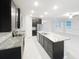 Modern kitchen with granite countertops, stainless steel appliances, dark wood cabinets, and white tile floor at 13014 Willow Grove Dr, Riverview, FL 33579