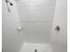 A crisp, white tiled shower featuring chrome shower head and soap dish at 13014 Willow Grove Dr, Riverview, FL 33579