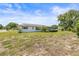 An angled view of the home's exterior and backyard featuring a partially screened patio at 1410 Brighton Ct, Palm Harbor, FL 34684