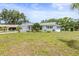 Well-maintained home with a lush lawn, mature trees, and classic architectural details enhancing curb appeal at 1410 Brighton Ct, Palm Harbor, FL 34684