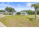 Charming home with lush landscaping, a well-manicured lawn, and an American flag in the front yard at 1410 Brighton Ct, Palm Harbor, FL 34684
