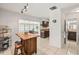 Open kitchen with an island and breakfast bar, leading to sunroom at 1410 Brighton Ct, Palm Harbor, FL 34684