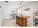 Bright kitchen with a wooden island, white cabinets, and tile flooring at 1410 Brighton Ct, Palm Harbor, FL 34684