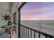Cozy balcony featuring a sun decoration, a table with chairs, and stunning ocean views at sunset at 14900 Gulf Blvd # 308, Madeira Beach, FL 33708