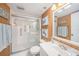 Bright bathroom featuring a step-in shower, framed mirror, turtle art, wood paneled walls, and beach themed decor at 14900 Gulf Blvd # 308, Madeira Beach, FL 33708