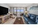 Comfortable living room with tile floors and sliding glass doors to a balcony with ocean view at 14900 Gulf Blvd # 308, Madeira Beach, FL 33708