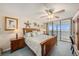 Comfortable main bedroom with a ceiling fan, ocean views and a large bed and matching dressers at 14900 Gulf Blvd # 308, Madeira Beach, FL 33708