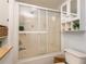 Bathroom with a shower featuring glass doors, neutral walls, ample storage and a toilet at 1512 56Th N Ave, St Petersburg, FL 33703