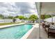 Backyard pool features lounge seating, privacy fence, and tropical landscaping for a relaxing outdoor space at 1512 56Th N Ave, St Petersburg, FL 33703