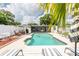Backyard pool with patio seating, outdoor kitchen, privacy fence, and tropical landscaping at 1512 56Th N Ave, St Petersburg, FL 33703