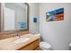 Stylish half-bathroom with a granite vanity, framed mirror, and decorative wall art at 1515 Bayshore Blvd # 38, Dunedin, FL 34698