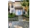 Inviting townhouse featuring a charming blue front door, covered entryway, and lush tropical landscaping at 1515 Bayshore Blvd # 38, Dunedin, FL 34698