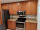 Well-equipped kitchen with stainless steel appliances, granite counters, and wood cabinetry at 1515 Bayshore Blvd # 38, Dunedin, FL 34698