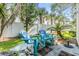 Inviting outdoor patio featuring stylish blue Adirondack chairs and tropical landscaping at 1515 Bayshore Blvd # 38, Dunedin, FL 34698