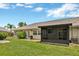 A view from the green backyard, complete with an enclosed lanai and side yard access, offers space and privacy at 1604 Comfy Ct, Sun City Center, FL 33573