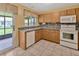 Corner view of kitchen featuring tile backsplash, double sink, and light countertops and cabinets at 1604 Comfy Ct, Sun City Center, FL 33573