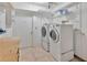 Laundry room with washer, dryer, storage shelving, and tile flooring at 1604 Comfy Ct, Sun City Center, FL 33573