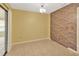 Spacious room with neutral tile flooring and a unique brick accent wall, ready for customization at 1604 Comfy Ct, Sun City Center, FL 33573
