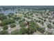Aerial view of a home surrounded by mature trees and lush landscaping in a quiet residential neighborhood near a lake at 1613 Long Pond Dr, Valrico, FL 33594