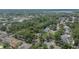 Aerial view of a home surrounded by mature trees and lush landscaping in a quiet residential neighborhood near a lake at 1613 Long Pond Dr, Valrico, FL 33594