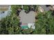 Aerial view of a home with a screened pool, surrounded by lush landscaping and trees at 1613 Long Pond Dr, Valrico, FL 33594