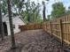 Fenced back yard featuring a wood fence, mature trees, and a natural ground cover at 1613 Long Pond Dr, Valrico, FL 33594
