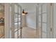 Bright bedroom featuring stylish French doors, light-colored wood-look flooring, and a ceiling fan at 1613 Long Pond Dr, Valrico, FL 33594