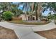 A single-story home with mature trees, lush landscaping, and a circular driveway at 1613 Long Pond Dr, Valrico, FL 33594