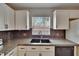 Kitchen featuring granite counters, tile backsplash, modern sink, and white cabinets at 1613 Long Pond Dr, Valrico, FL 33594