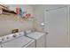 A functional laundry room equipped with a modern washer and dryer and extra shelving at 1613 Long Pond Dr, Valrico, FL 33594