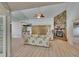 Bright living room featuring a stone fireplace, ceiling fan, and wood floors at 1613 Long Pond Dr, Valrico, FL 33594