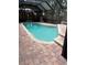 In-ground pool in a screened enclosure, surrounded by brick pavers offering a relaxing outdoor space at 1613 Long Pond Dr, Valrico, FL 33594