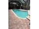 In-ground pool in a screened enclosure, surrounded by brick pavers offering a relaxing outdoor space at 1613 Long Pond Dr, Valrico, FL 33594