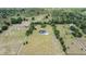 Expansive aerial view of modern farmhouse on large lot with mature trees and long driveway at 17566 Hyland Ln, Dade City, FL 33523