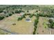 Expansive aerial view of modern farmhouse on large lot with mature trees and long driveway at 17566 Hyland Ln, Dade City, FL 33523