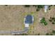 Aerial view of modern home with pool, long driveway and large green lawn surrounded by mature trees at 17566 Hyland Ln, Dade City, FL 33523