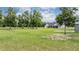 Expansive backyard view with a modern white house, screened-in porch, and lush green lawn with mature trees at 17566 Hyland Ln, Dade City, FL 33523
