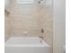 Clean bathroom with a sleek tub, overhead shower, and modern fixtures at 17566 Hyland Ln, Dade City, FL 33523