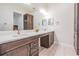 Bright bathroom featuring dual sinks, stylish fixtures, and plenty of storage space in wood finish cabinets at 17566 Hyland Ln, Dade City, FL 33523