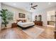 A bedroom with wood floors, ceiling fan, two dressers, and a view of the outdoors at 17566 Hyland Ln, Dade City, FL 33523