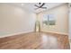Light, airy bedroom with wood-look floors, large window, ceiling fan, and full length mirror at 17566 Hyland Ln, Dade City, FL 33523