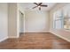 Bright bedroom features wood-look flooring, ceiling fan, and large window providing natural light at 17566 Hyland Ln, Dade City, FL 33523