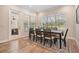 Bright dining room with wood floors, large windows, and elegant table set for six at 17566 Hyland Ln, Dade City, FL 33523