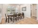 Dining room featuring wood floors, a six-chair table, and a serene outdoor view at 17566 Hyland Ln, Dade City, FL 33523