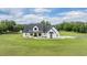 Charming modern farmhouse with black trim, white siding, covered porch, and green lawn at 17566 Hyland Ln, Dade City, FL 33523