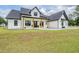 Inviting front porch with rocking chairs, wooden posts, and modern farmhouse design at 17566 Hyland Ln, Dade City, FL 33523